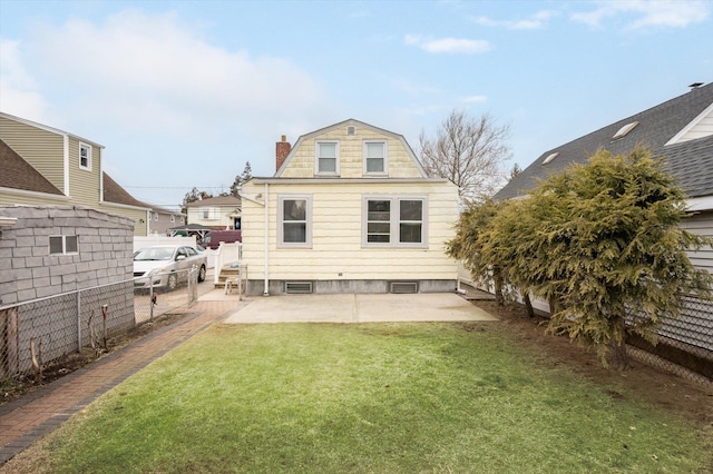 back of property with a chimney, a patio area, fence, and a lawn