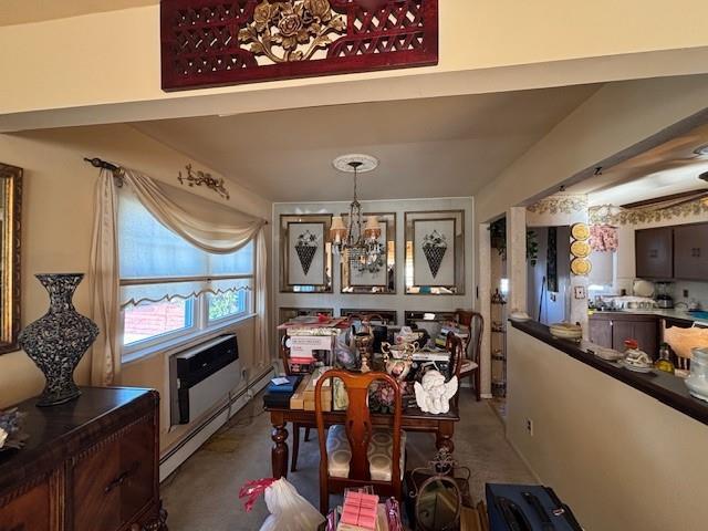 dining space with a chandelier, a baseboard radiator, and a wall unit AC