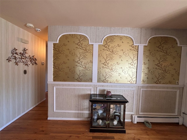 details featuring a baseboard radiator, wood finished floors, and wallpapered walls