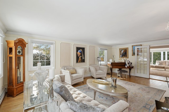 living room featuring baseboards, ornamental molding, french doors, light wood-style floors, and a baseboard radiator