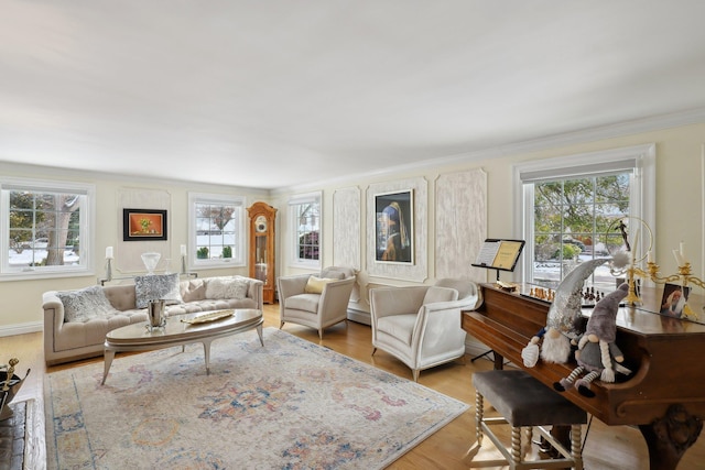 living room with light wood-type flooring, a wealth of natural light, and ornamental molding