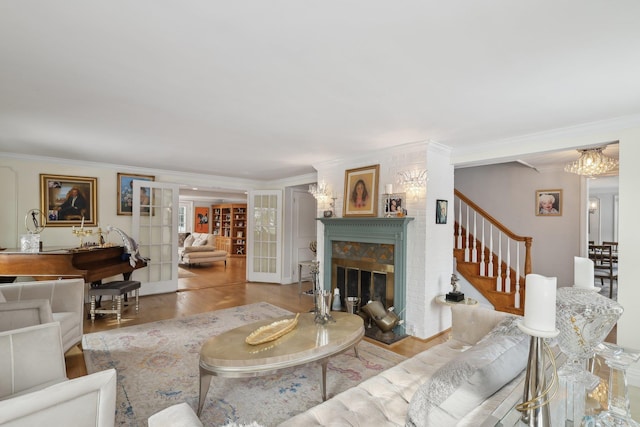 living area featuring french doors, a stone fireplace, wood finished floors, and crown molding