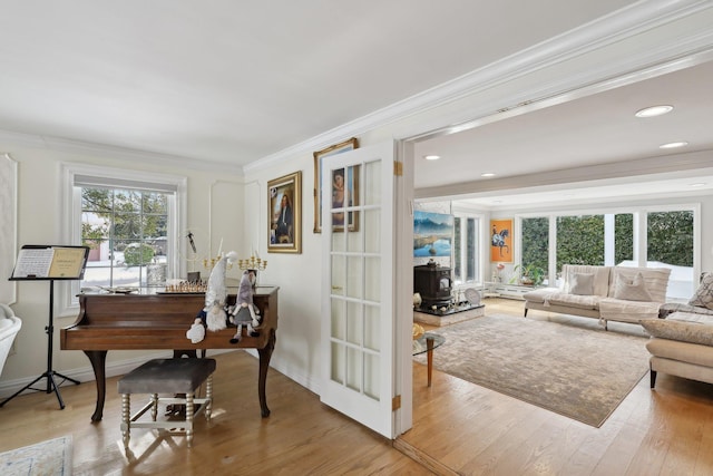 interior space featuring recessed lighting, baseboards, wood finished floors, and ornamental molding