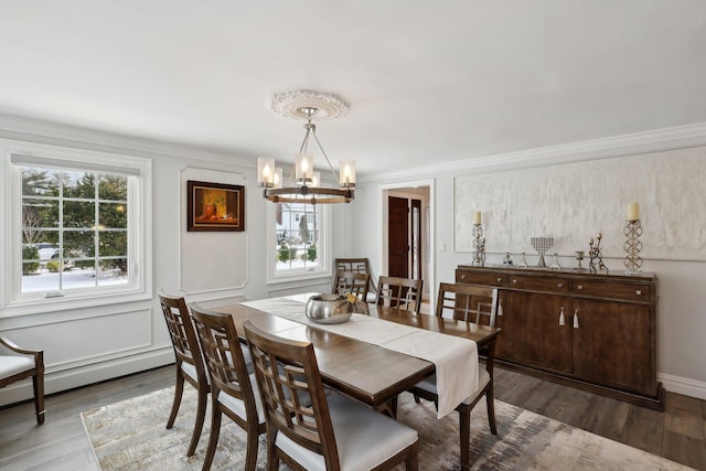 dining space featuring an inviting chandelier, crown molding, wood finished floors, and a baseboard radiator