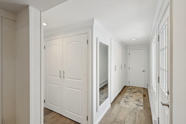 corridor with a baseboard heating unit, crown molding, and light wood-style flooring