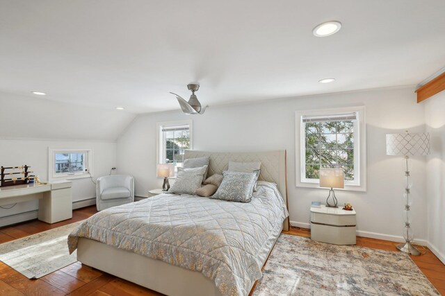 bedroom with a baseboard heating unit, baseboards, lofted ceiling, wood finished floors, and a ceiling fan