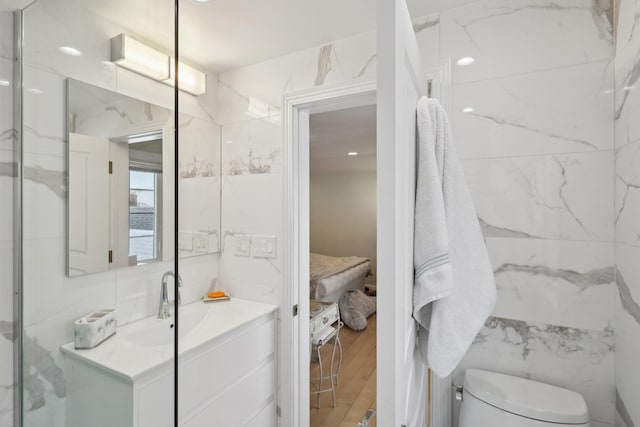 full bathroom featuring vanity, tile walls, toilet, and wood finished floors