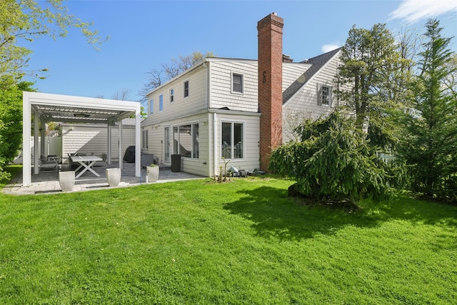 rear view of house featuring a lawn, a patio, and a chimney