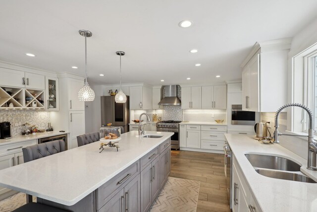 1570 Stevenson Rd, Hewlett, NY 11557 - kitchen with a sink, wall chimney range hood, appliances with stainless steel finishes, tasteful backsplash, and recessed lighting