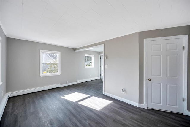 empty room with a baseboard heating unit, baseboards, and dark wood-style floors