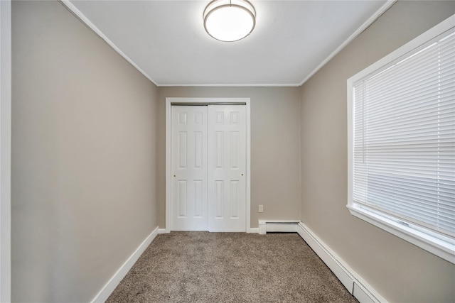 unfurnished bedroom featuring carpet floors, a closet, a baseboard heating unit, and baseboards