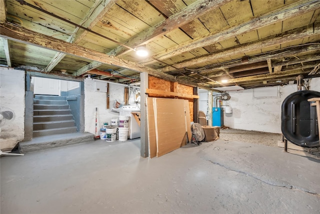 unfinished basement featuring heating fuel, stairs, and washer / dryer