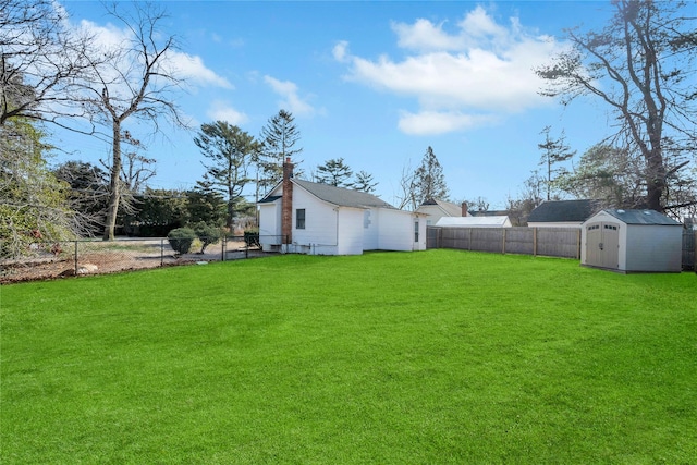 view of yard with an outbuilding, a storage shed, and a fenced backyard