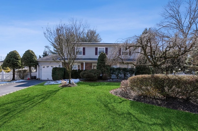 traditional-style home with driveway, a garage, fence, and a front lawn