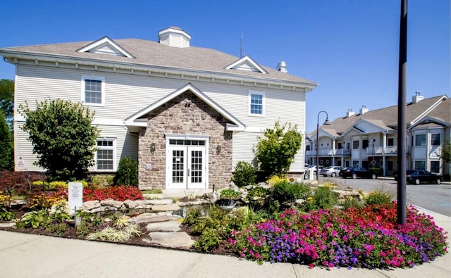 view of front facade featuring stone siding and french doors