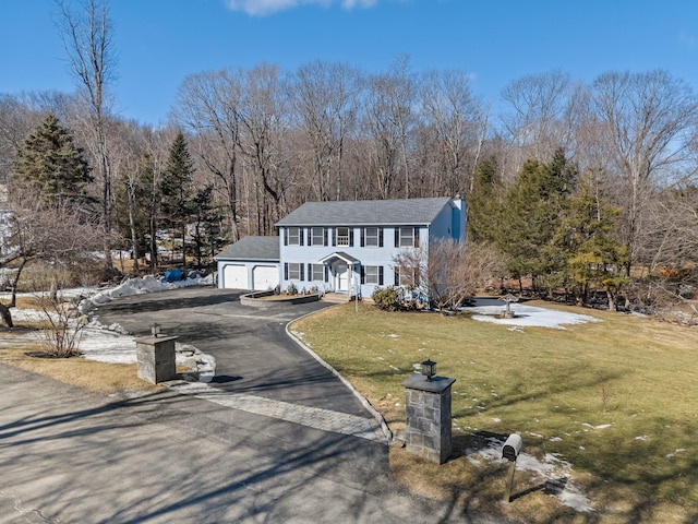 view of front facade with an attached garage, driveway, and a front lawn