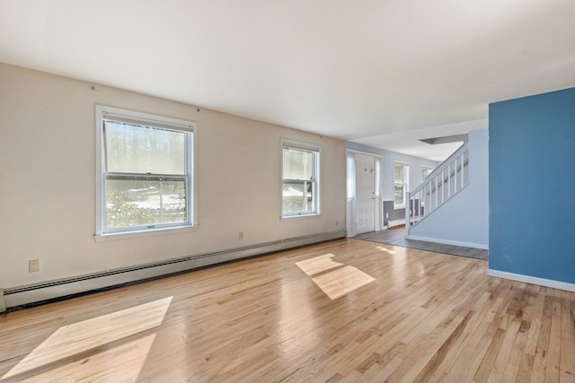 unfurnished living room featuring a baseboard radiator, a baseboard heating unit, wood finished floors, baseboards, and stairs