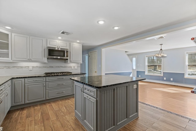 kitchen featuring a baseboard radiator, visible vents, gray cabinetry, appliances with stainless steel finishes, and light wood-type flooring