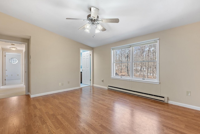 empty room featuring baseboards, a baseboard heating unit, ceiling fan, and wood finished floors