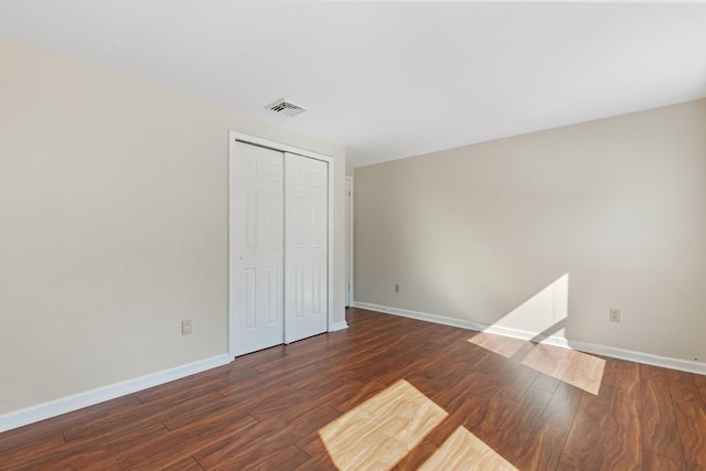 unfurnished bedroom featuring visible vents, baseboards, and wood finished floors