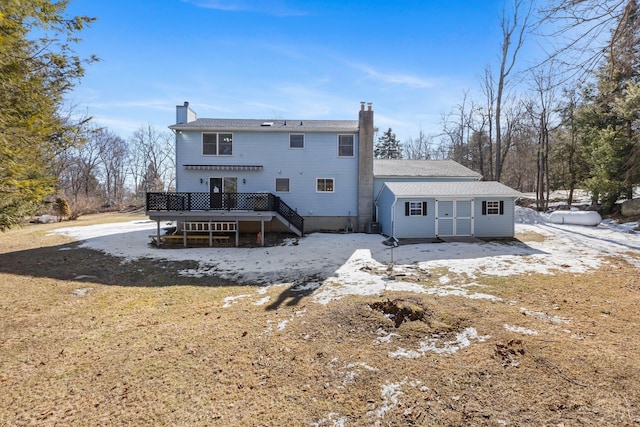 back of property with a chimney and a wooden deck