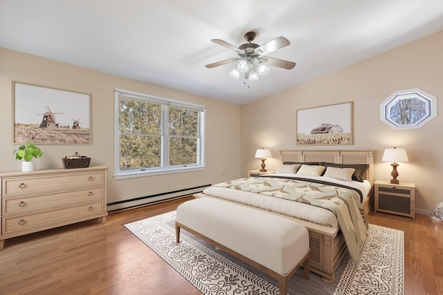 bedroom with a baseboard heating unit, vaulted ceiling, light wood finished floors, and ceiling fan