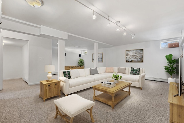 living room with a baseboard heating unit, light carpet, rail lighting, and baseboards