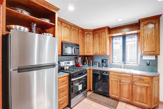 kitchen with black appliances, a sink, light countertops, and brown cabinets