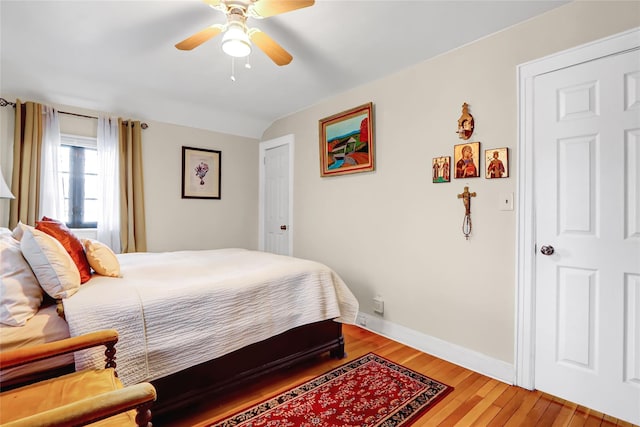 bedroom featuring ceiling fan, baseboards, vaulted ceiling, and wood finished floors