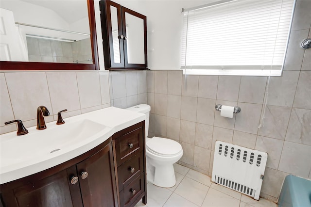 full bathroom with tile walls, toilet, radiator heating unit, vanity, and tile patterned flooring