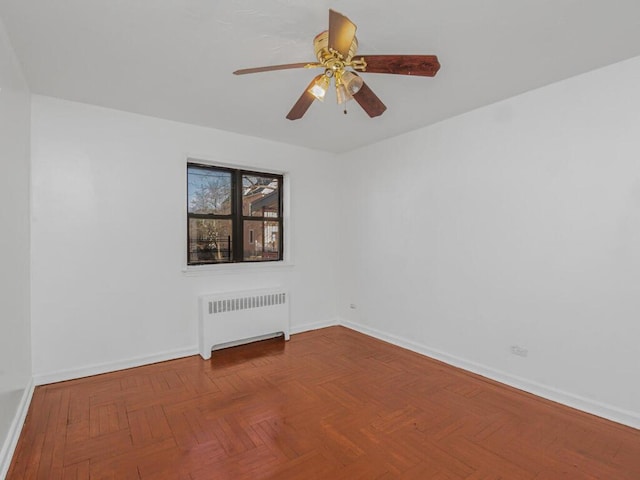 unfurnished room featuring ceiling fan, radiator heating unit, and baseboards