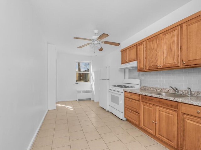 kitchen with tasteful backsplash, radiator heating unit, a sink, white appliances, and under cabinet range hood