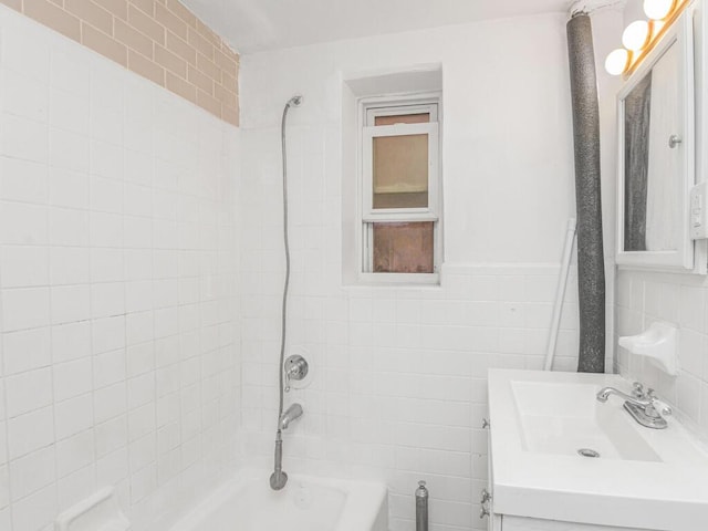 bathroom featuring a wainscoted wall, shower / bathing tub combination, vanity, and tile walls