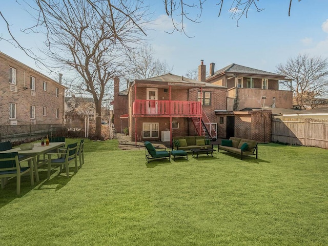 rear view of property with brick siding, a chimney, a lawn, stairway, and an outdoor hangout area