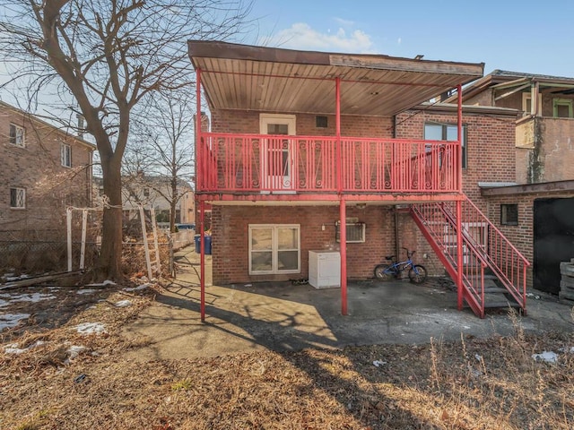 back of property with a patio area, stairway, and brick siding