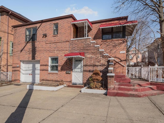 view of front facade featuring an attached garage, concrete driveway, and brick siding