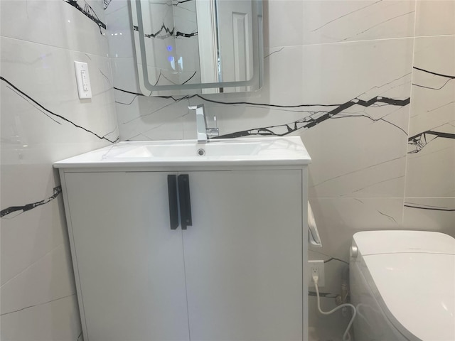 half bath featuring toilet, tile walls, and vanity