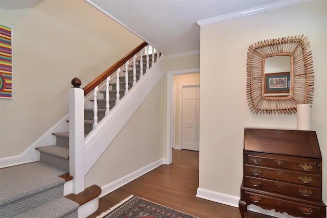 stairs featuring baseboards, wood finished floors, and crown molding