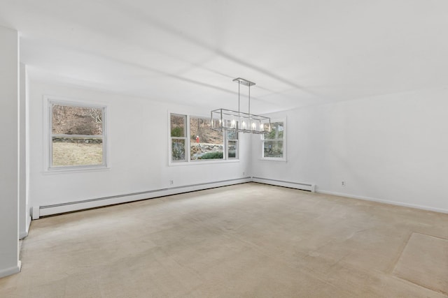 carpeted empty room featuring baseboards, a baseboard heating unit, and a notable chandelier