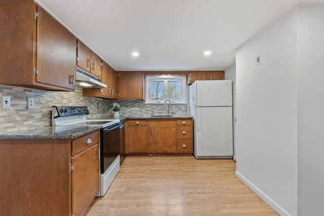 kitchen with tasteful backsplash, electric range oven, light wood-style floors, freestanding refrigerator, and under cabinet range hood