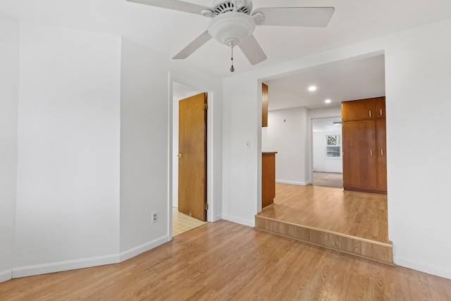 spare room featuring light wood-type flooring, baseboards, a ceiling fan, and recessed lighting