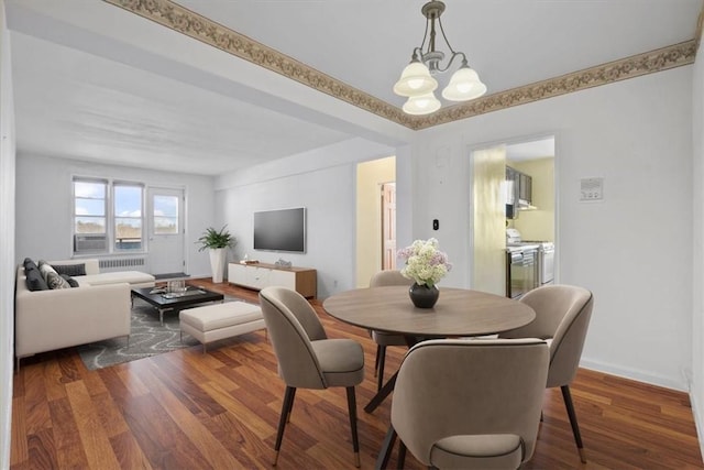 dining space with dark wood-style floors, baseboards, radiator heating unit, and an inviting chandelier