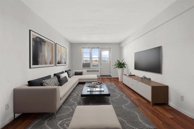 living area featuring radiator, dark wood-style floors, and baseboards