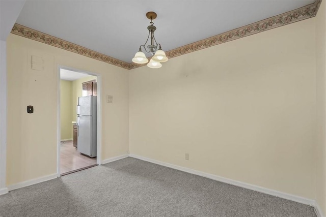 spare room featuring light colored carpet, baseboards, and an inviting chandelier