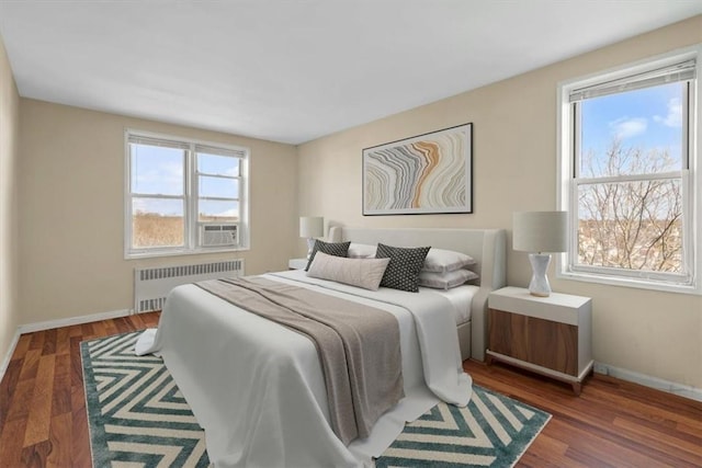 bedroom with dark wood-style flooring, radiator heating unit, cooling unit, and baseboards