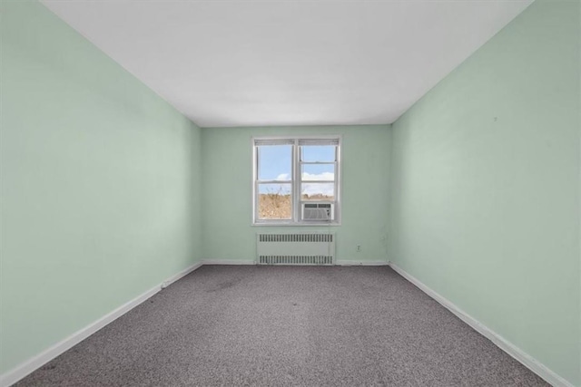 empty room with baseboards, carpet floors, cooling unit, and radiator