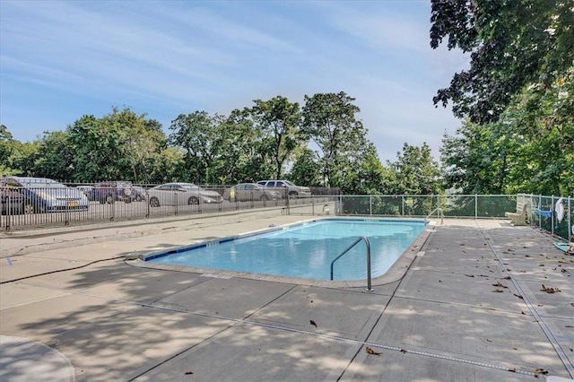 community pool with fence and a patio