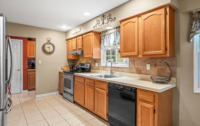 kitchen featuring under cabinet range hood, tasteful backsplash, stainless steel appliances, and a sink