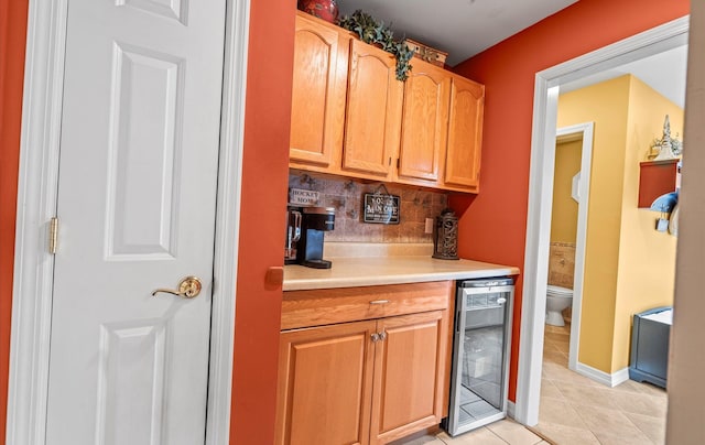 bar featuring wine cooler, light tile patterned flooring, baseboards, backsplash, and a bar