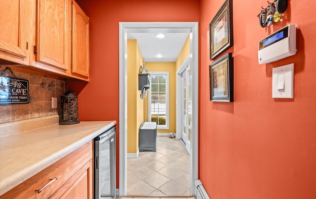 kitchen featuring light tile patterned floors, tasteful backsplash, beverage cooler, baseboards, and light countertops